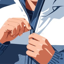 A hand pulling a zipper to close a jacket