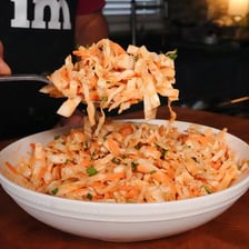 A serving of creamy coleslaw beside barbecue food.