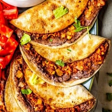A Mexican taco filled with meat, vegetables, and toppings
