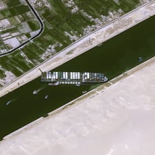Ships traveling through the Suez Canal between desert banks