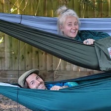 A person resting comfortably in a hammock.