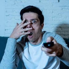 A person showing fear during a suspenseful situation.