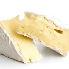 A round wheel of Brie cheese showing its characteristic white rind.