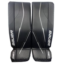 An ice hockey goalie wearing large protective leg pads