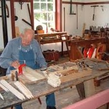 A craftsperson producing an object in a workshop.