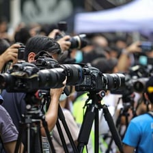 Reporters and cameras gathered during intense breaking-news coverage.
