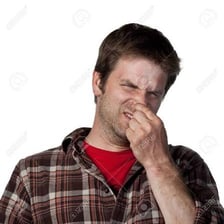 A person covering their nose in reaction to an unpleasant smell