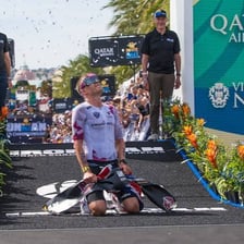 A triathlete crossing an Ironman finish line