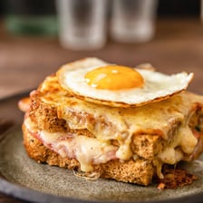 A croque madame topped with a fried egg