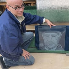 An artist engraving a design on a glass surface
