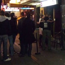 A nightclub bouncer examining a patron's identification card