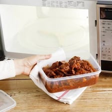 A dish of leftovers being reheated in a microwave.