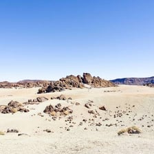 A dry desert landscape with sparse vegetation.
