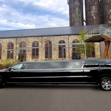 A long limousine parked at a curb.