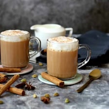 A cup of spiced chai latte topped with cinnamon