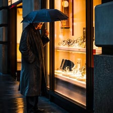 A shopper looking at merchandise through a storefront window