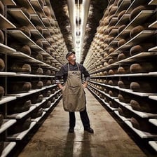 A wheel of cheese aging in a cool storage cellar