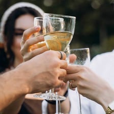 A maid of honor speaking at a wedding reception with a raised glass