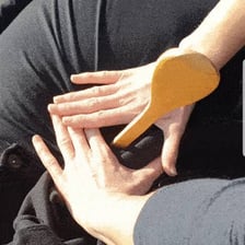 A hand pressing firmly against an object.