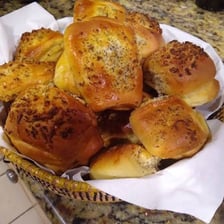 A round bakery roll topped with baked onion pieces