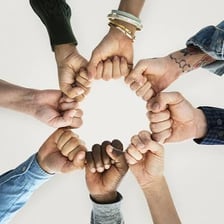 People from two groups joining hands.