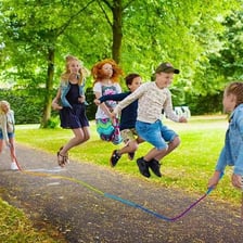 Children jumping between two turning ropes.