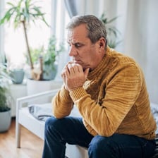 A visibly tense person sitting nervously.