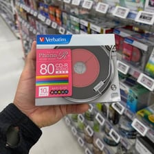 A recordable compact disc beside a computer CD burner.
