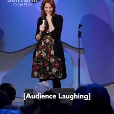A comedian performing for a laughing audience.
