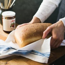 A freshly baked loaf of bread on a kitchen table.