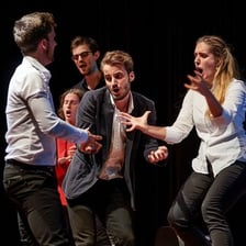 Actors performing a scene on a theater stage