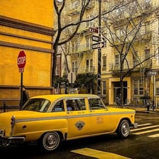 A taxi cab driving on a city street