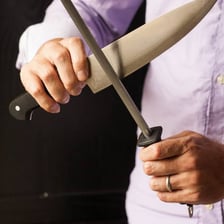 A knife blade being sharpened with a honing steel.
