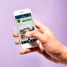 A person uploading a photo to Instagram on a smartphone.