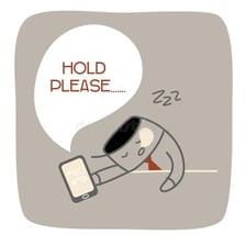 A person waiting while holding a telephone.