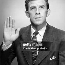 A person raising a hand while making an oath