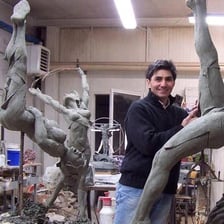 A sculptor shaping a work of art in a studio