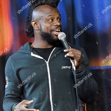 A host holding a microphone at a comedy roast.