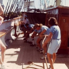 A sailor singing on the deck of a ship.
