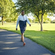 A person walking quickly along a park path.