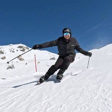 An alpine skier balancing with ski poles
