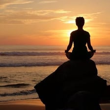 A person meditating peacefully in a quiet setting.