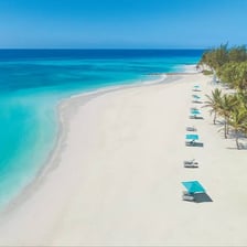 A tropical all-inclusive resort beside a beach and swimming pool.