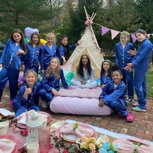 Teenagers gather for a sleepover with pillows and blankets.