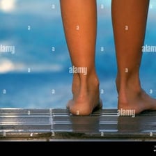 A person's bare feet standing in a swimming pool.