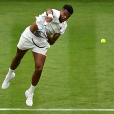 A tennis player delivering a serve.