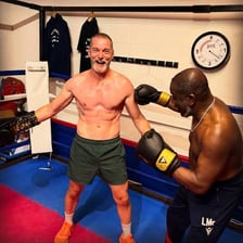 Two boxers practicing punches in a boxing ring