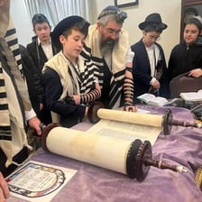 An open Torah scroll on a reading stand