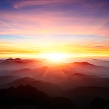The sun rising above the horizon at dawn