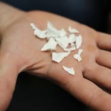 Paper being cut into many narrow pieces by a shredder